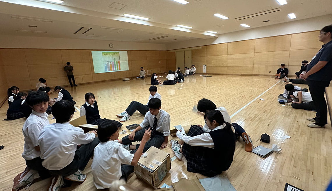 段ボール等で自前の楽器を作り、絵本のページのイメージを音で表現する生徒たち