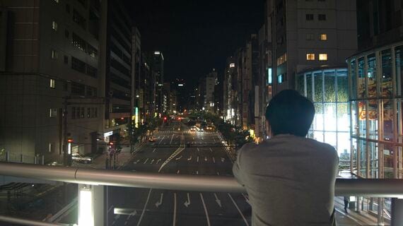 夜の街を眺める男性