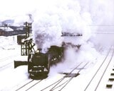 雪の倶知安駅を発車するC62形重連牽引の急行「ニセコ」（撮影：南正時）