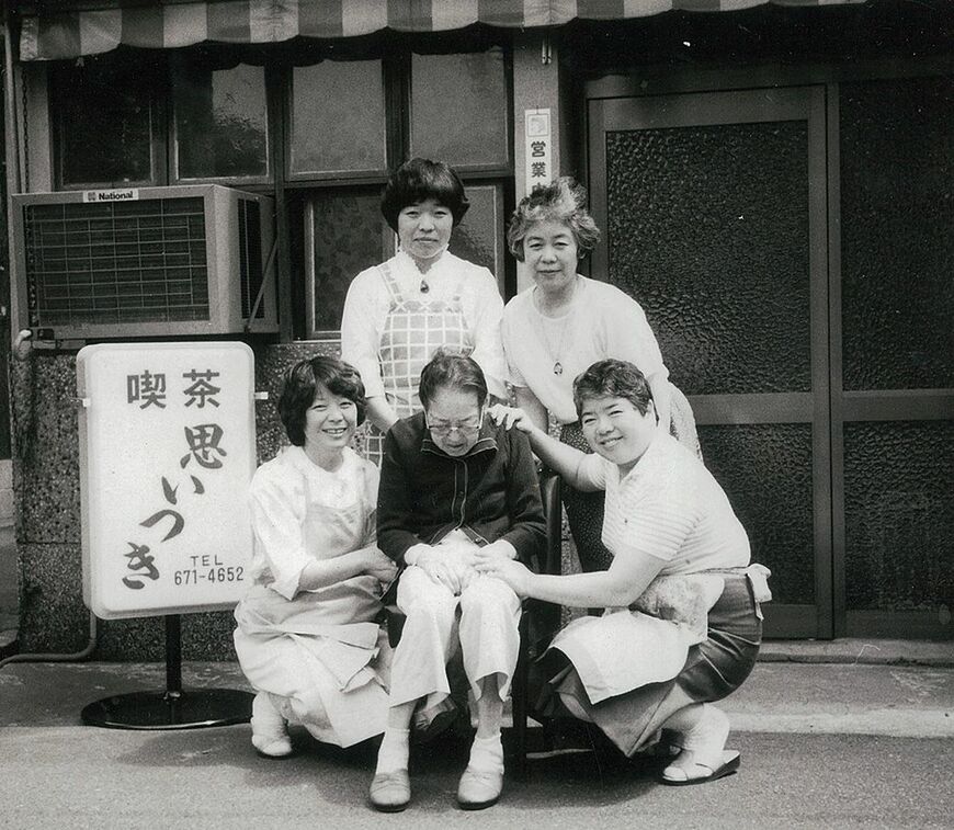 1986（昭和61）年、店の前で母・なみ江さんを囲む四姉妹（撮影：神戸船渠工業株式会社）