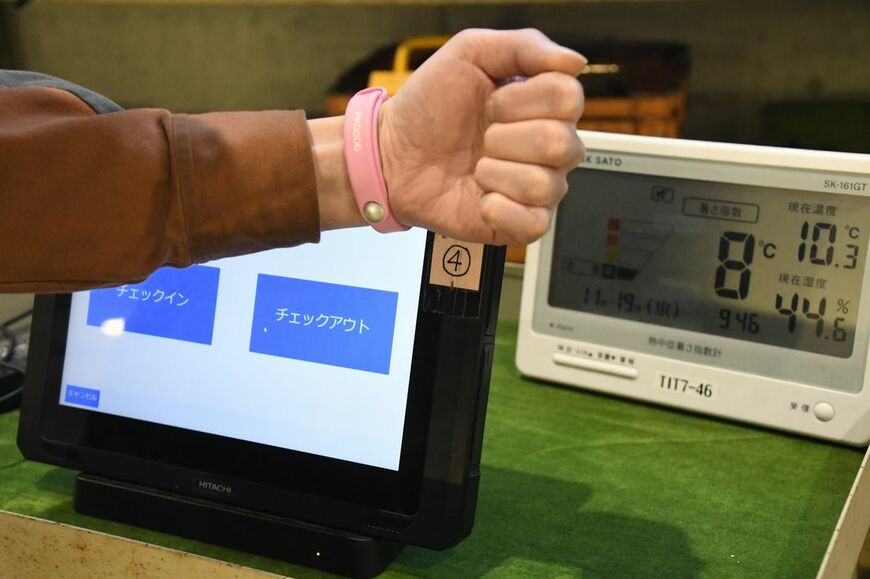 日立の「HMAX」によって車両メンテナンスのDX化を進める東武鉄道。写真は作業員の属性や作業内容、作業時間を把握する「チェックイン・チェックアウトシステム」。リストバンドとタブレットを使う（記者撮影）