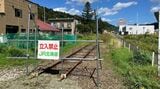 旧夕張駅に続く廃線路。駅前のホテルは巨大な廃墟となった（筆者撮影）