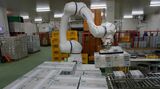 湯田牛乳公社の本社工場の冷蔵庫内で、1日1800箱を運搬用パレットに積載する作業を行う、安川電機の協働ロボット。従業員は力仕事から解放された（記者撮影）