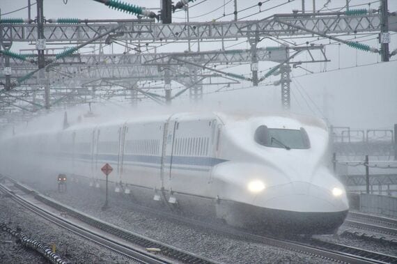 雨の中を走る東海道新幹線（写真：ユキユキ / PIXTA）