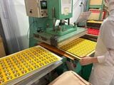 紙とアルミ箔を重ねたフタのシートに熱を加え、容器と圧着する（筆者撮影）