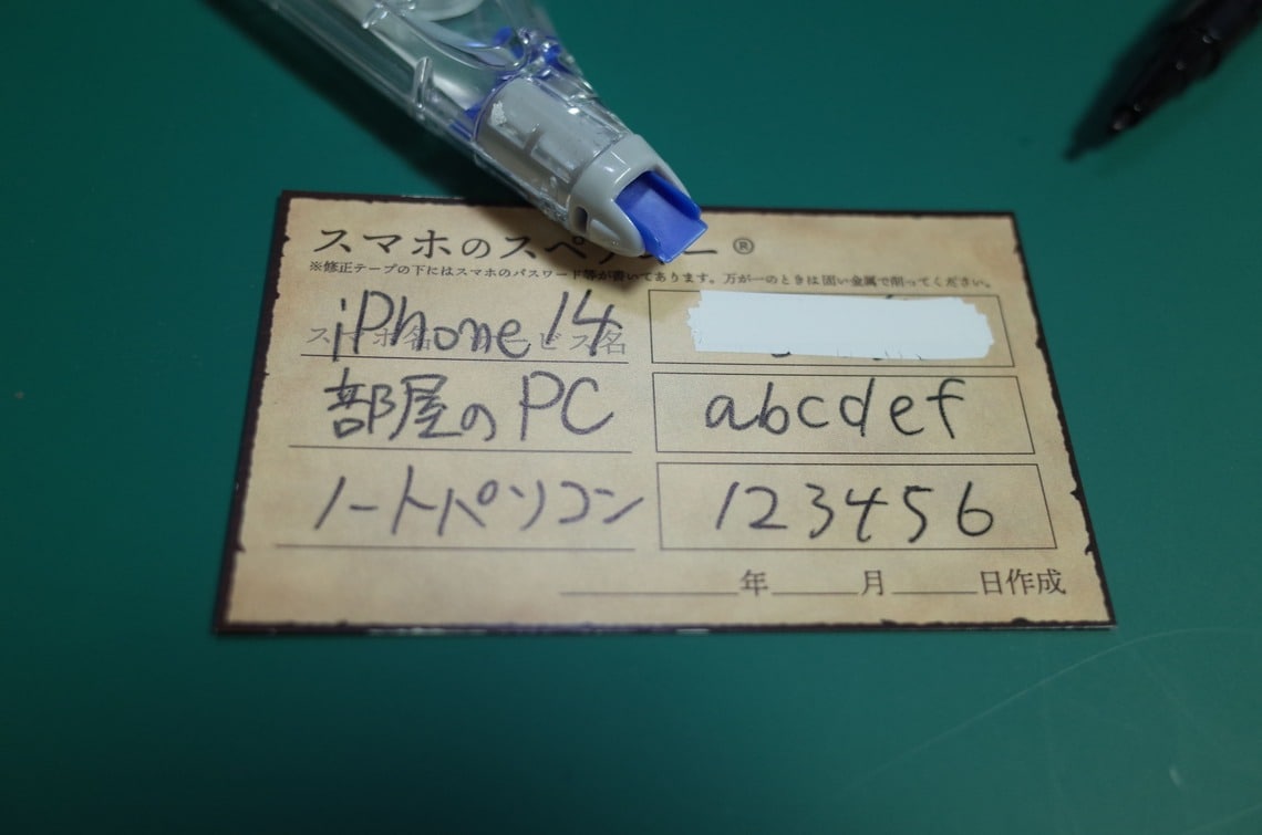 パスワード部分だけ修正テープを2～3回走らせる。裏が透けるなら裏にも走らせる（筆者撮影）