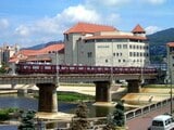 宝塚歌劇の本拠地、宝塚大劇場をバックに武庫川を渡る今津線の電車（撮影：南正時）