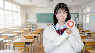 丸のサインを持つ学生