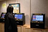 手前のパネルでまず注文し、奥の機器で精算を済ませる（撮影：今祥雄）