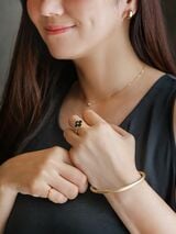 ネックレス、リング、ブレスレットをゴールドのアクセアリーで統一