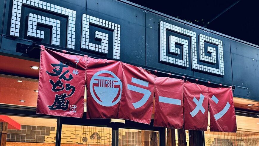 赤い暖簾と黒い外装が印象的な店頭。（筆者撮影）