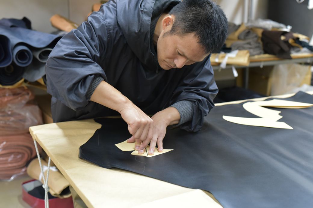 北嶋製靴代表取締役の北嶋浩治さん。革を裁断している様子（写真：北嶋製靴）