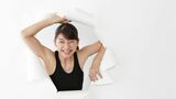 大きな紙を破った穴から顔を出す女性