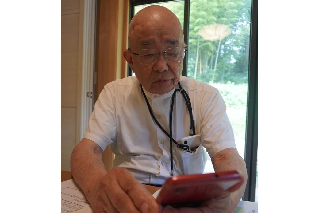 相談者からの電話が届くスマホを手に（写真：弁護士ドットコム）
