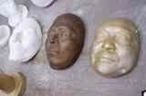 工房に置かれたデスマスク。奥から石膏のみ、ブロンズ像、石膏像に金色の塗装を施したもの（筆者撮影）