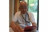 相談者からの電話が届くスマホを手に（写真：弁護士ドットコム）
