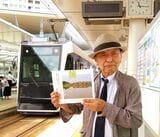 写真集を手に福井鉄道「フクラムライナー」の前に立つ筆者（写真：南正時所蔵）