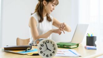 時計とオフィスの女性