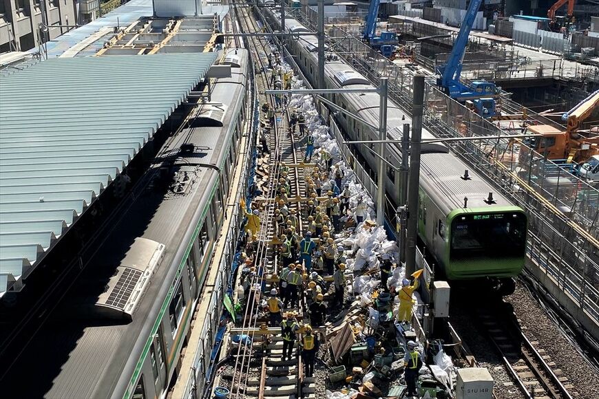 両側を電車が走る中での線路切り換え工事（記者撮影）