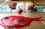 生後1カ月の円君と、島民が「出産祝いに」と持ってきてくれたタイ（画像提供：片野田隆紀）