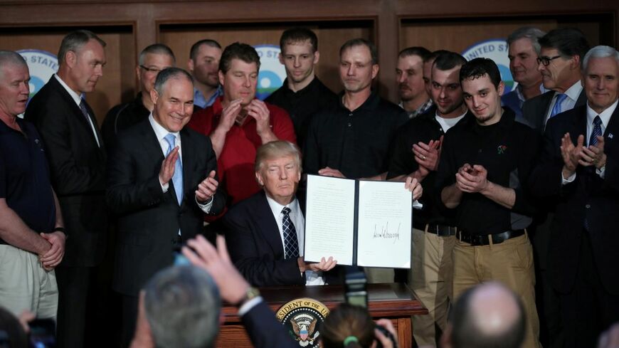 2017年3月、温暖化規制見直しの大統領令に署名するトランプ大統領（当時）。「2期目のリスク」はどう管理すればいいのだろうか（写真：ロイター／アフロ）