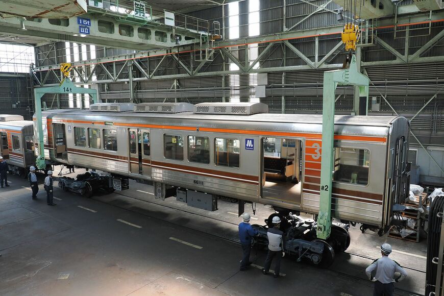 「架台下ろし」作業の様子。2基の天井クレーンで吊り上げる（撮影：伊原薫）