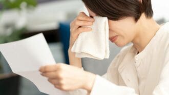 書類を読んで泣く女性