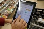 タブレットを見ながら、店員が在庫を確認する