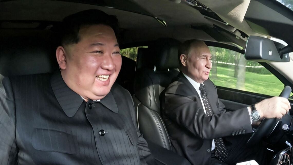 ロシアの高級車「アウロス」に乗り、平壌空港から市内へ向かう北朝鮮の金正恩総書記（左）と訪朝したロシアのプーチン大統領（写真・AFP=時事）