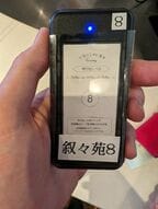 叙々苑からの呼び出しを待つ。叙々苑の名が刻印された呼び出し用のデバイスもなかなか珍しい（筆者撮影）