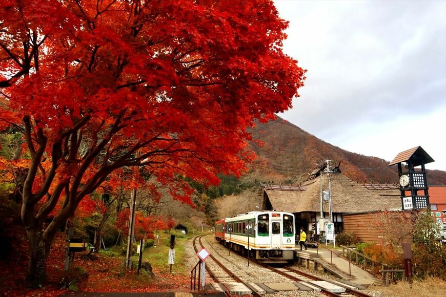 紅葉の湯野上温泉駅と会津鉄道の気動車（撮影：南正時）