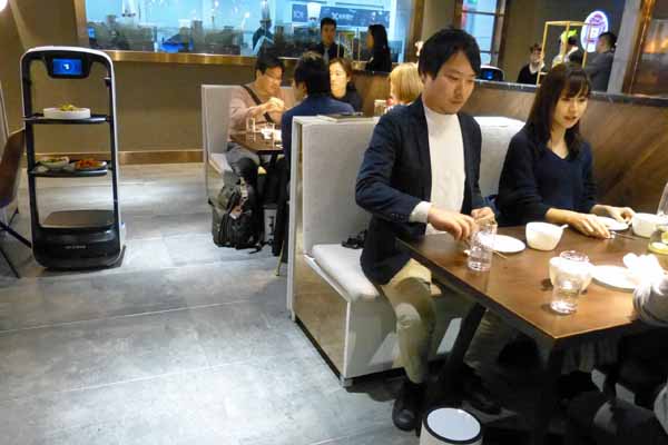 配膳ロボットが客席へ料理を運ぶ（記者撮影）