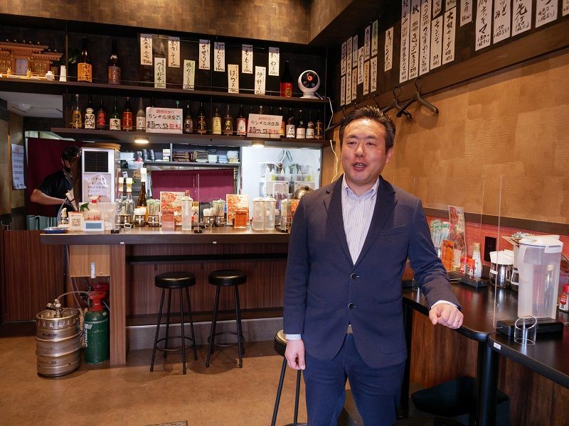 マリーエンターダイニングの小川晋平専務取締役。店内は、一人で訪れる客が多いため、昼間は全席カウンター席にレイアウトを変更している（筆者撮影）