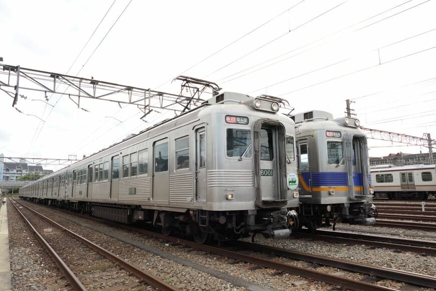 ステンレス無塗装復活デザインの6000系（左）と現行塗装の6000系（記者撮影）