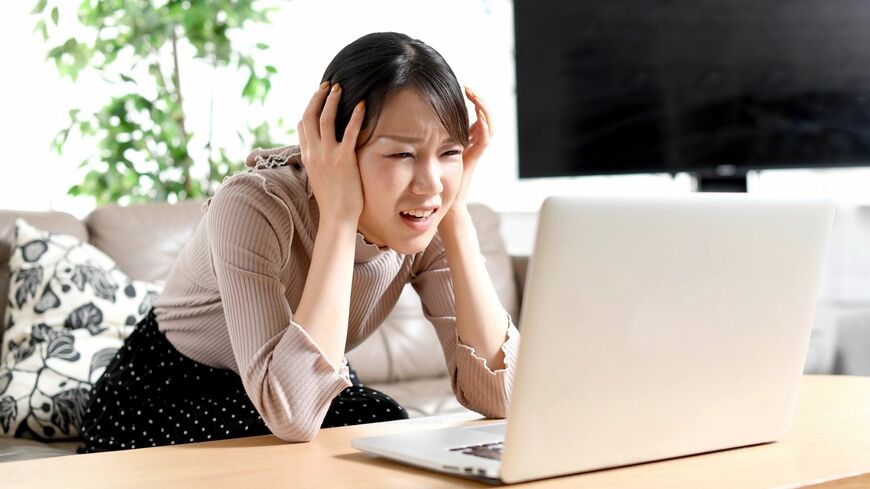 株式投資に失敗し、頭を抱える女性