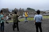 串本駅到着後に見学する国の天然記念物「橋杭岩」では地元ボランティアガイドが説明する（記者撮影）