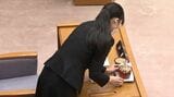 石川県議会の知事席に置かれているガラス製水差しの水滴を丁寧に拭き取る女性職員（写真：石川テレビ放送）