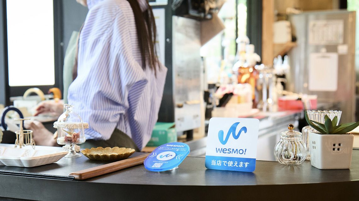 飲食店のカウンターに設置されたWesmo!の端末とポップ