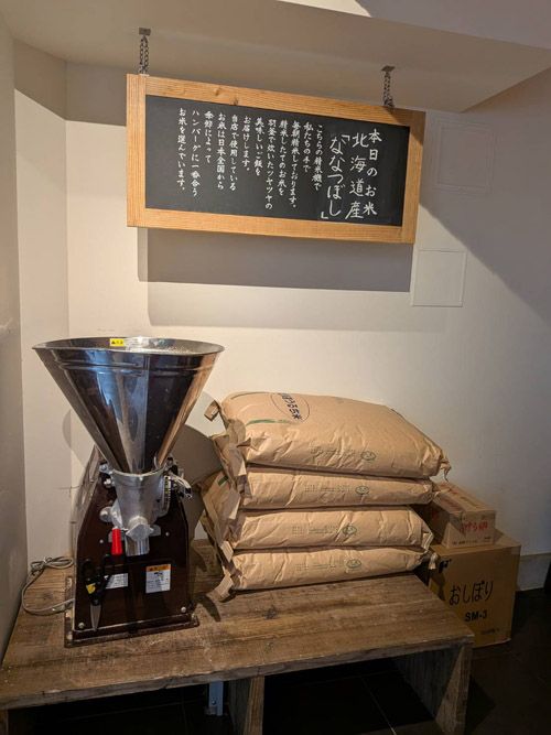 渋谷の劇場型ハンバーグ店「君のハンバーグを食べたい」は、店内の一角に精米機を置き、さらに米の袋を積んでごはんへのこだわりをアピール。お客の期待を高める見せ方がうまい（筆者撮影）