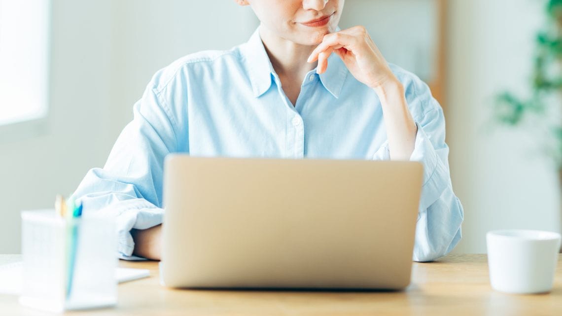 パソコンの画面を見ながら考える女性