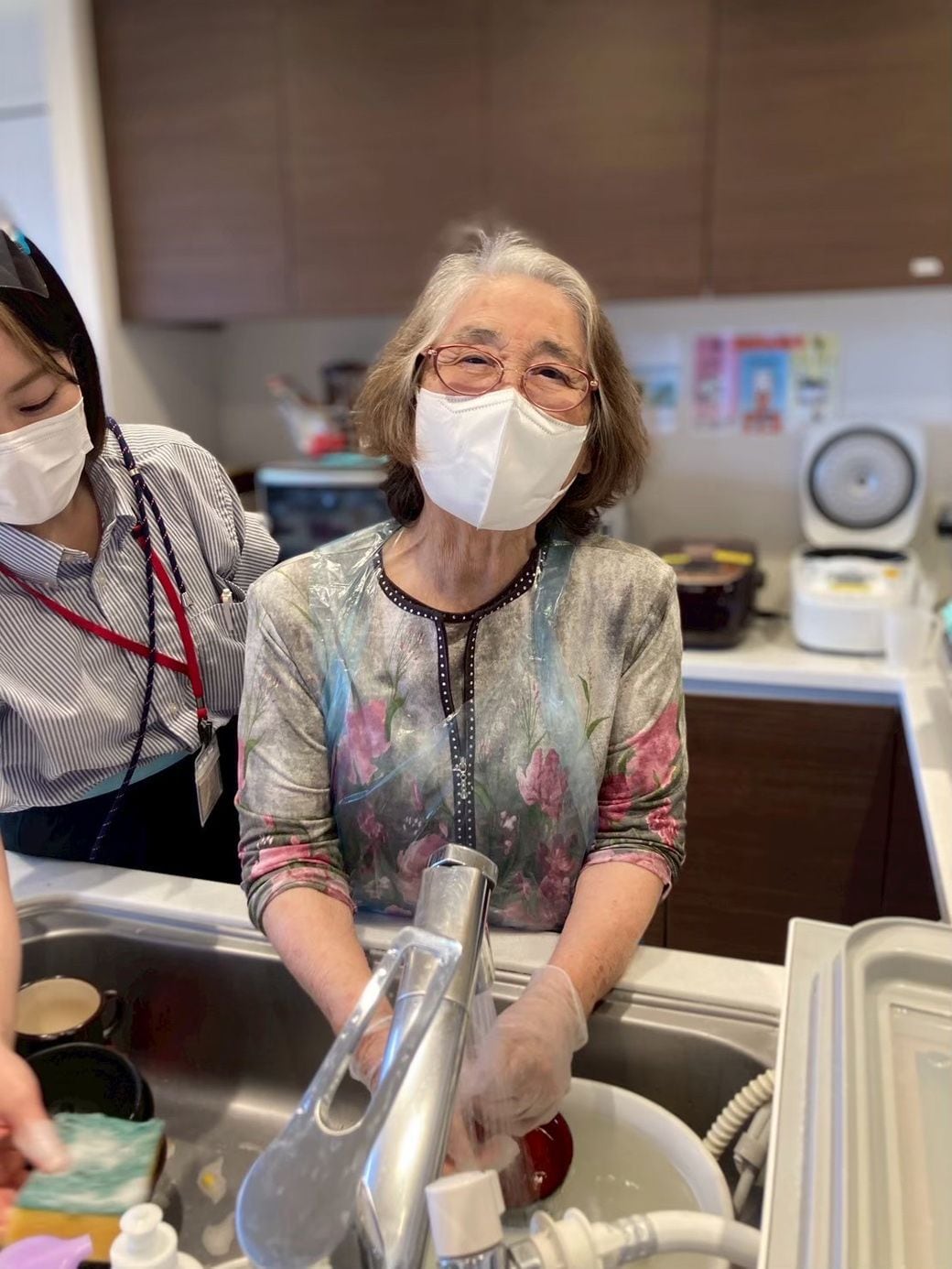 デイサービスで食器洗いの手伝いをする伊東さん（写真：「世田谷中町」提供）