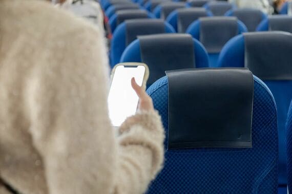 新幹線車内でスマホを触る人物