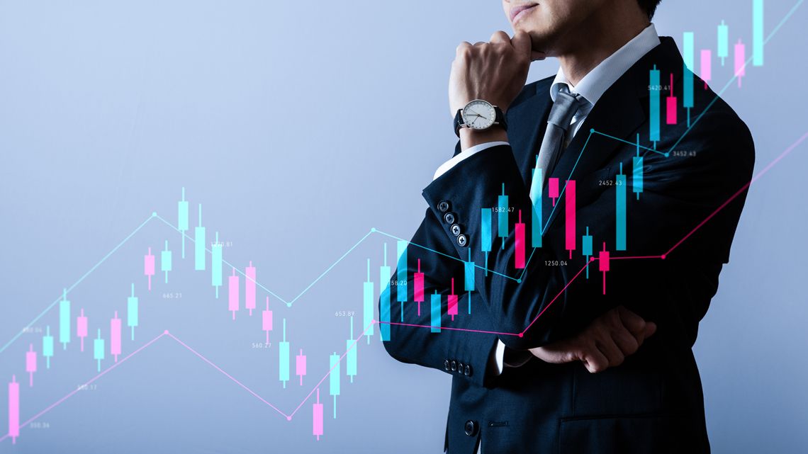 株価チャートのイメージと思案するビジネスパーソン