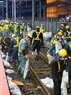 線路のバラストを整える作業員ら