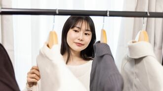 部屋で洋服を選ぶ人物