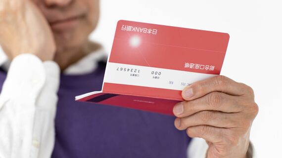 通帳を見て悩むシニア