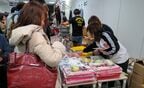 選手のグッズを買い求める女性ファン