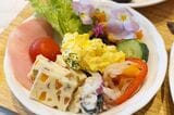 サラダを取り分けたお皿。カラフルなメニューが多く、グリーンサラダにエディブルフラワーが入っていることもあり、華やかに仕上がった（写真：筆者撮影）