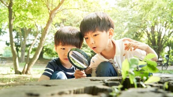 虫眼鏡をのぞく男の子