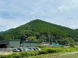 谷口さんの自宅横に建てられた工場（左手緑色の建物）。自然豊かな山に囲まれた場所にある（筆者撮影）